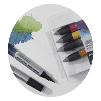 Package of Winsor and Newton graphic markers with two lying open next to green and blue scribbles.